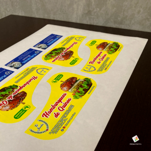 Muestra de planillas de etiquetas adhesivas personalizadas con suaje en forma, impresas en full color para empaques y productos.